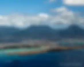 Coming in for landing, overflying the reef runway, as a ship leaves Pearl Harbor . . .
