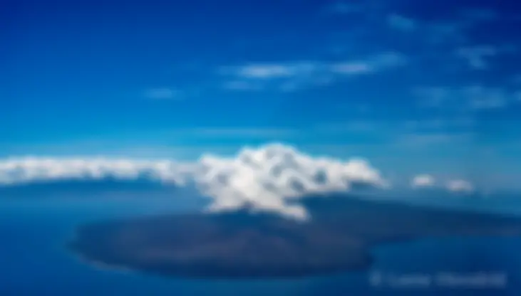The island of Lanai, with west Maui in the background, and a crown of convective clouds, on a midmorning flight viewed from 7000 feet . . .