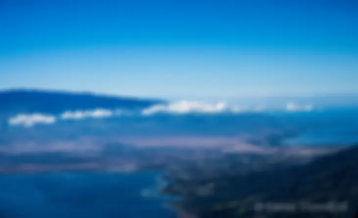 Looking across the central valley towards Haleakala, from a perch in the sky above west Maui in the morning; the peak of Mauna Kea is seen faintly in the distance . . .