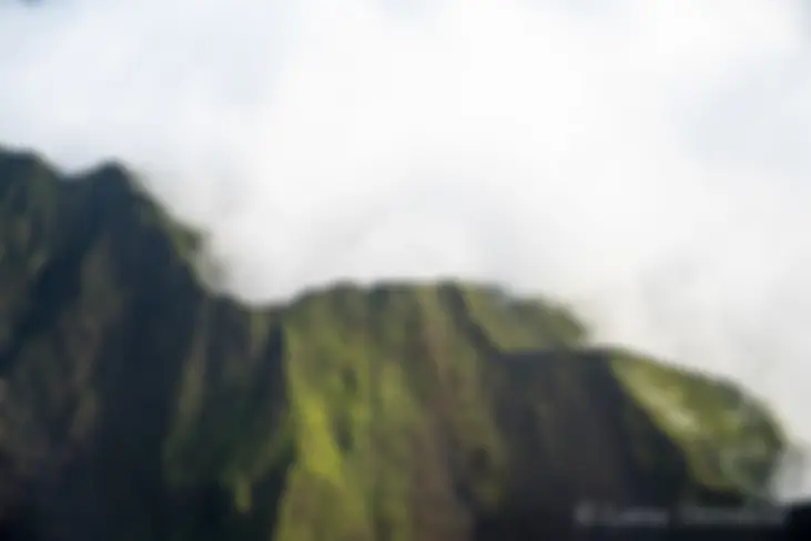 The lush green crests of west Maui mountains, filled with clouds . . .