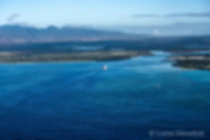 We follow a ship entering Pearl Harbor on Oahu, in the early morning, with the Waianae Mountains as a backdrop . . .